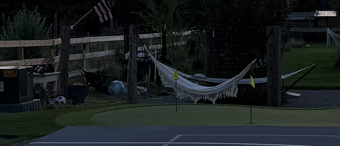 Hammocks, putting green flags, and Adirondack chairs around the fire pit